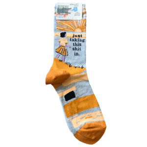 grey and orange socks with girl and sunset image reads "just taking this shit in"