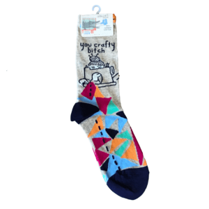 grey and multicolor socks with woman at sewing machine "you crafty bitch"