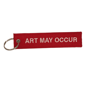 red keychain with white text "ART MAY OCCUR"