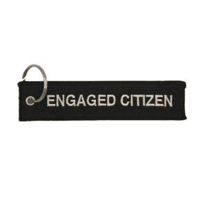 black fabric keychain with white embroidered text "ENGAGED CITIZEN"