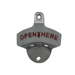 A metal bottle opener with mounting screw holes and red letters that say "open here"